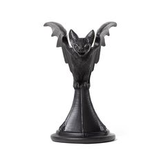 a statue of a bat with wings on it's head and eyes open, in front of a white background