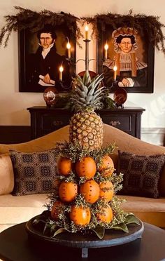 there is a pineapple on top of some oranges in the middle of a living room