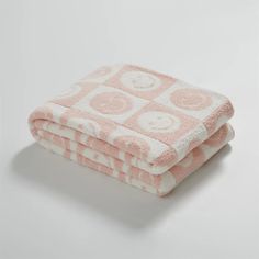 two towels folded on top of each other in pink and white circles, with one towel folded