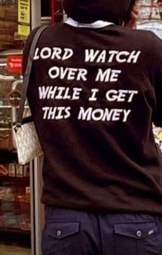 the back of a person wearing a shirt that says lord watch over me while i get this money