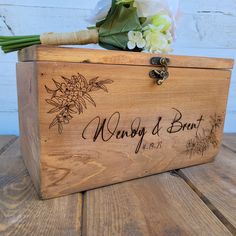 a wooden box with flowers and writing on the lid that says nobody's been