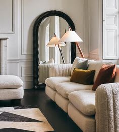 a living room filled with furniture and a large mirror