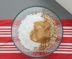 a glass bowl filled with food on top of a red and white striped table cloth