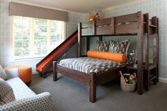 a bedroom with bunk beds and a slide in the corner