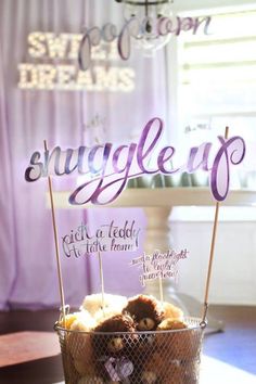 a basket filled with doughnuts sitting on top of a table next to a sign that says snuggle up