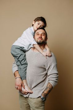 a man holding a small child on his shoulders