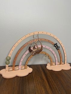 a pair of wooden rainbows on top of a table next to a wall mounted clock