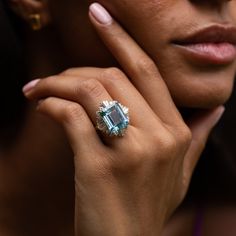 The Story A gorgeous vintage ring made during the late 20th century, with the perfect pop of color. It centers around 10.61 carat emerald cut aquamarine in the most beautiful blue hue. Surrounding it in the classic ballerina style are 28 diamonds, a mixture of round brilliant and baguette cuts, ranging from 0.05 to 0.09 carats each, giving the ring a total diamond weight of approximately 1.84 carats. The diamonds settings and variety of dimensions give the ring visual movement. All done in 18 ka Gold Vintage Ring, Ballerina Style, 18k Gold Ring, Diamond Settings, Baguette Cut, Late 20th Century, Vintage Ring, Round Brilliant Cut Diamond, Blue Hues