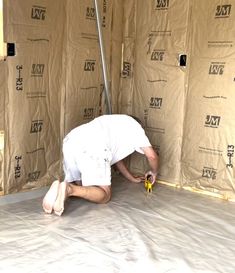 a man laying on the ground in front of a wall with some tape around it