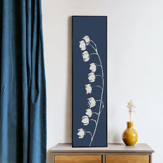 a painting is hanging on the wall next to a dresser with a vase in front of it