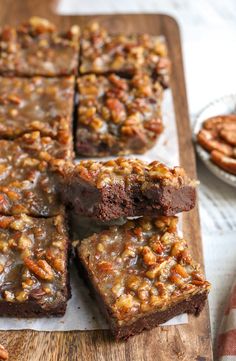 brownies with pecan toppings cut into squares on a cutting board