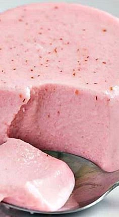 a cake with pink frosting on a silver plate