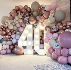 the number forty four surrounded by balloons and flowers