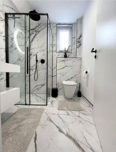 a white bathroom with marble floors and walls