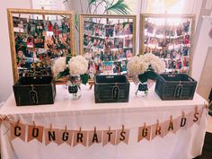 three vases filled with white flowers sitting on top of a table next to pictures