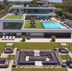 an aerial view of a modern house with pool and lawn furniture in the foreground