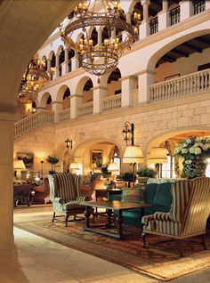 an elegant hotel lobby with chandelier and seating