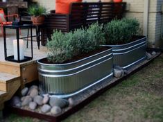 an outdoor patio with metal planters filled with plants