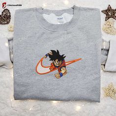 Introducing the ultimate fusion of style and fandom – the Goku x Nike Swoosh Anime Embroidered Tshirt. This Dragon Ball-inspired shirt combines the iconic Nike swoosh with Goku’s power-packed persona, creating a design that’s a must-have for any anime enthusiast. Crafted with meticulous attention to detail, the embroidered artwork brings Goku to life, showcasing his electrifying superpowers. Made from premium quality fabric, this shirt offers unrivaled comfort and durability, e Buu Dbz, Ethereal Realm, Nike Inspired, Goku And Chichi, Best Family Gifts, Hoodie Ideas, Embroidered Shirts, Balls Shirt, Anime Tshirt