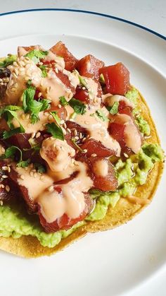 a taco topped with meat and vegetables on top of a white plate