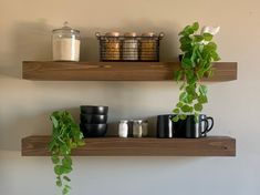 two wooden shelves with plants and mugs on them