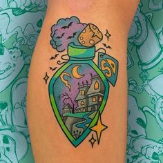 a tattoo on the leg of a woman with an image of a castle in a jar