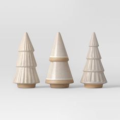 three white ceramic christmas trees are lined up