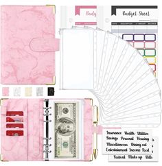 a pink planner with lots of notes and money in it's pocket, along with other items