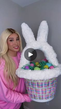 a woman holding up a basket with eggs in it and an easter bunny costume on