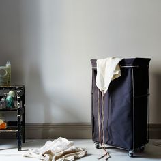 a black suitcase sitting on top of a white floor next to a table and chair