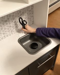 a child is playing with scissors on the counter