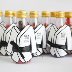 several bottles with black and white designs on them are lined up in the shape of karate kimonos