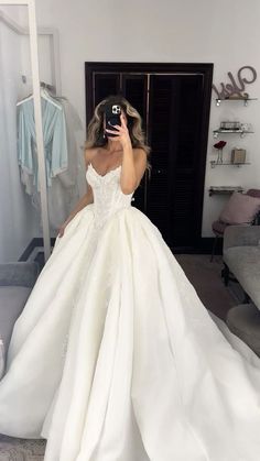 a woman is taking a selfie in her wedding dress while she takes a photo