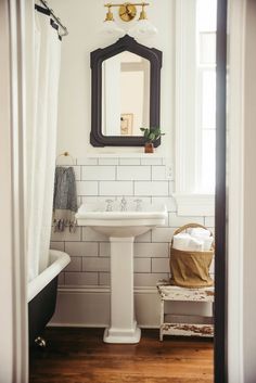 a white sink sitting under a mirror in a bathroom