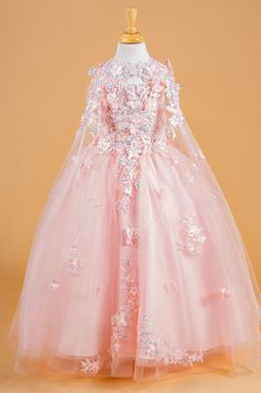 a pink flower girl dress on a mannequin headdress with white flowers