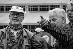 an old man pointing at something while standing next to two older people