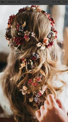 a woman with long hair wearing a flowered headpiece on top of her head