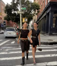 two women walking across a cross walk holding hands