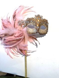 Pink and gold mask- Women's Mask- feather mask- Mardi Gras - 1920s mask- Holiday Mask -Halloween -Masked ball -Masquerade Party mask Hello, This feather stick mask is a stunning stopper and is made with pink coque feathers are about to 8 inch. They fan out and are placed on a beautiful golden mask with lace overlay. Mask colors: A) Gold solid B) Gold/ tan crackle (Shown) C) Silver solid D) Silver/ tan crackle Black Rose gold The huge rhinestone setting that is 4 inches with rhinestone that match Halloween Masked Ball, Mardi Gras Makeup, Mardi Gras Wedding, Golden Mask, Mask Carnival, Masquerade Ball Party, Diy Carnival, Carnival Mask, Feather Mask