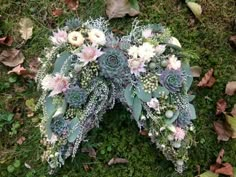 an arrangement of succulents and flowers on the ground