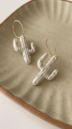 two pairs of earrings sitting on top of a plate