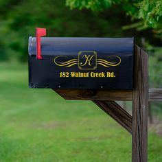 a black mailbox sitting on top of a wooden post