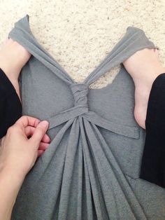 a person is holding onto the back of a dress that has been folded over it