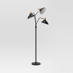 the three light floor lamp is black and has two lamps on each side of it