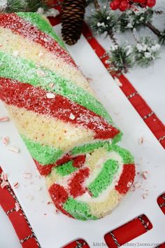 a colorful cake on a white plate with red and green frosting