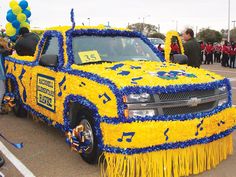 a yellow and blue truck with musical notes on it's side is parked in a parking lot