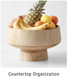 a wooden bowl filled with different types of fruit