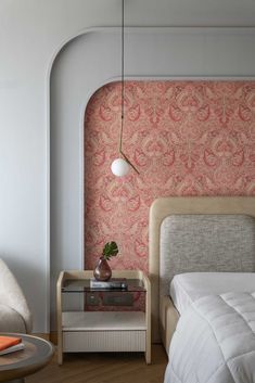 a bedroom with pink wallpaper and a bed in the corner next to a nightstand