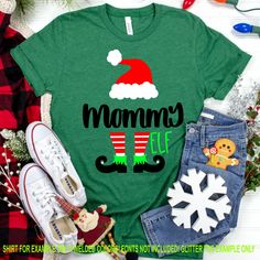 a green shirt with the words mommy elf on it and some christmas decorations around it