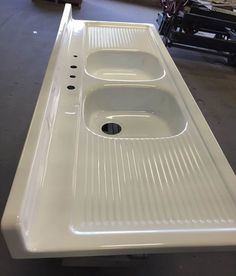 a white sink sitting on top of a counter in a room next to other items